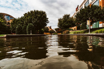 Swimming pool by lake against buildings in city