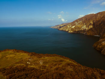 Scenic view of sea and mountains against sky