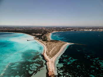 Aerial view of swimming pool by sea against clear sky