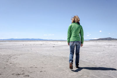 Full length of woman standing against blue sky