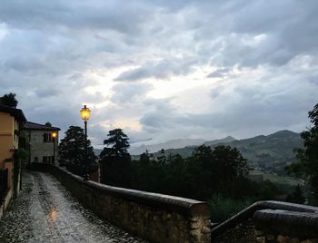 Illuminated buildings by mountain against sky