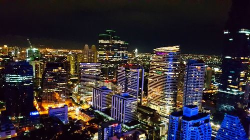 High angle view of illuminated buildings against sky at night