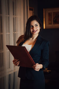 Portrait of smiling young woman standing at home