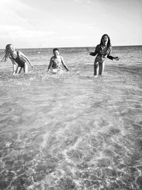 People enjoying in sea against sky