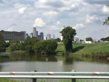 Scenic view of river by buildings against sky