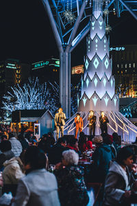 People on illuminated street at night