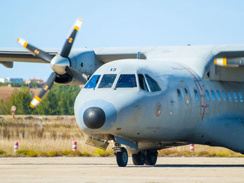 Airplane on airport runway against sky