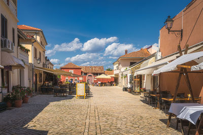 Street amidst buildings in town against sky