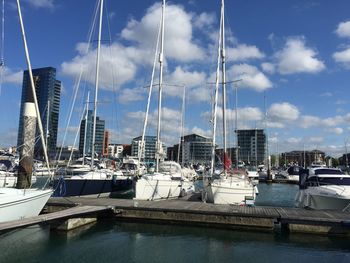 Sailboats moored at harbor in city