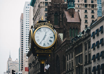 Low angle view of clock tower amidst buildings in city