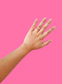 Close-up of hands over pink background