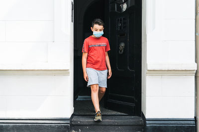 Full length of boy standing against building