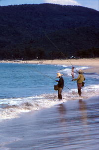 Rear view of man fishing in sea