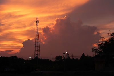 Low angle view of electricity pylon against sky during sunset