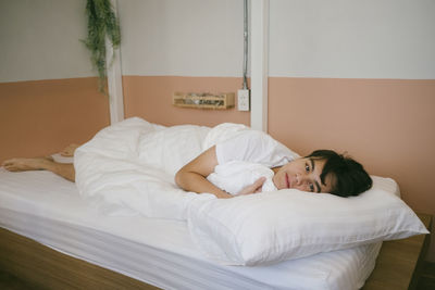 Portrait of woman relaxing on bed at home