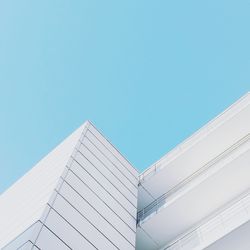 Low angle view of modern building against clear blue sky