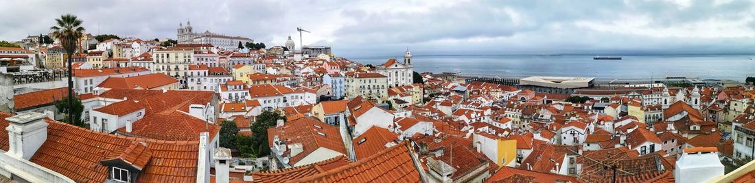 High angle view of townscape by sea against sky
