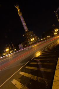 Light trails on road against sky at night