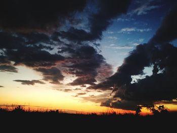 Low angle view of silhouette landscape against dramatic sky