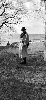 Full length of woman standing on field against sky