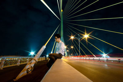 Light trails on road against sky at night