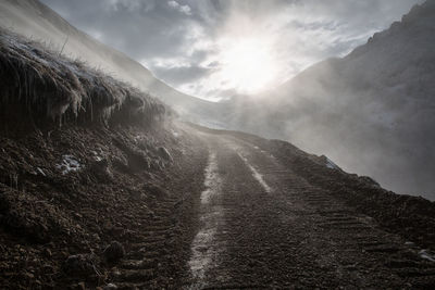 The road in the mountains in the fog. scenic view of mountains against sky