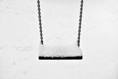 Close-up of swing on snow covered field