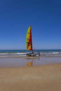 Lifeguard hut on beach against clear blue sky