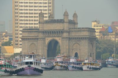 Boats in river with buildings in background