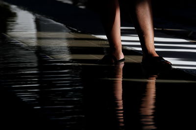 Low section of woman standing in water