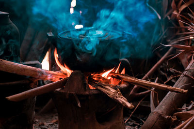 Cooking food in container on burning firewood