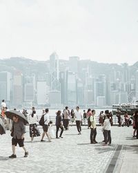 Group of people in city against clear sky