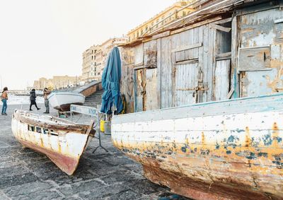 Abandoned boats moored in old building against clear sky