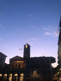 Low angle view of buildings in town against blue sky