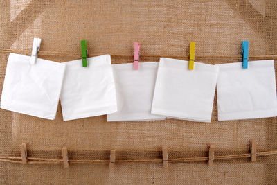 Close-up of clothespins hanging against white wall
