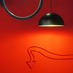 Close-up of illuminated lamp against red background