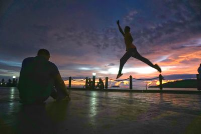 Silhouette of man with arms outstretched in water