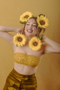 Portrait of smiling woman with yellow flower
