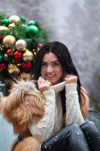 Portrait of smiling woman sitting outdoors during winter