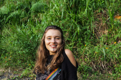 Portrait of young woman standing against plants