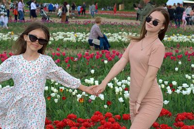 Women standing by flowering plants