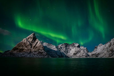 Scenic view of lake and mountains against sky at night
