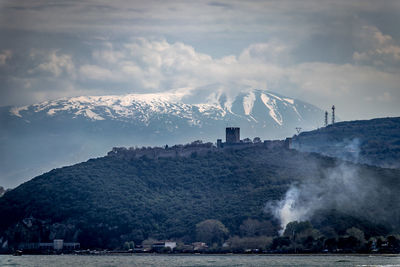 Smoke emitting from mountain against sky