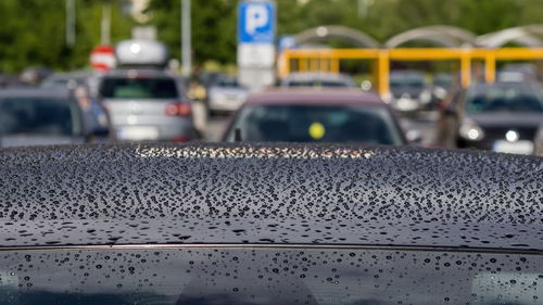 Rain drops on the black car roof sunny summer day