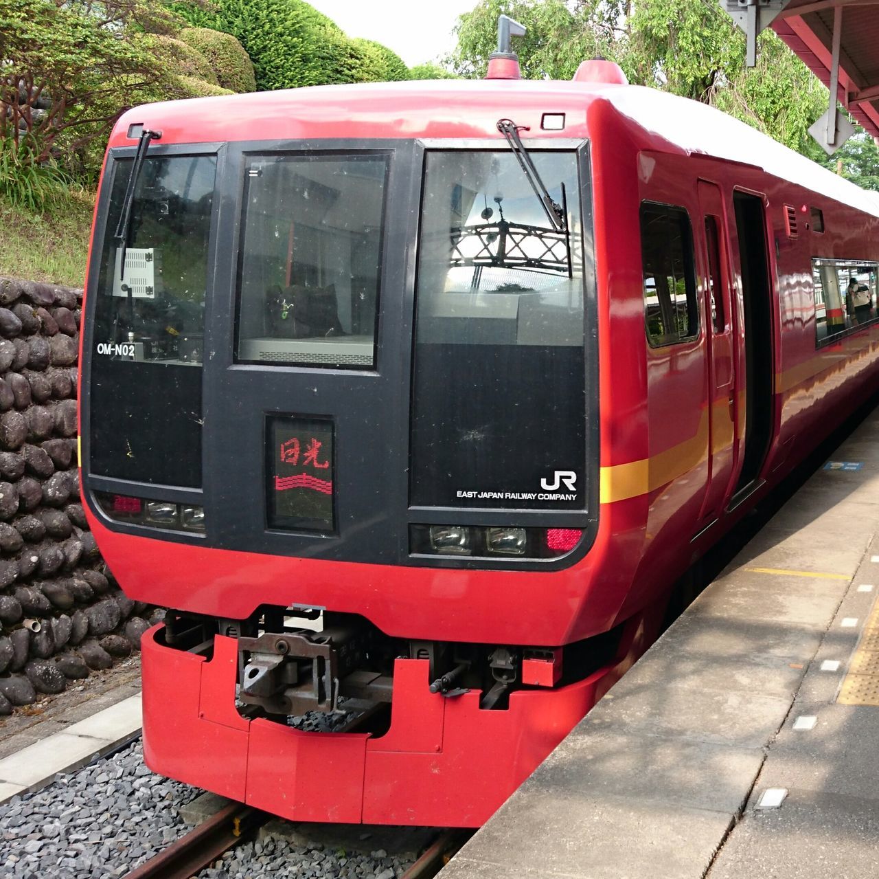 red, transportation, rail transportation, public transportation, railroad track, train - vehicle, communication, railroad station, passenger train, text, railroad station platform, mode of transport, train, built structure, building exterior, day, architecture, western script, travel, metal