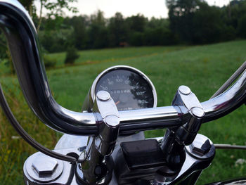 Close-up of cropped motorcycle on grassy field