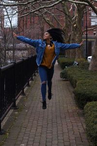 Full length of happy woman with arms outstretched