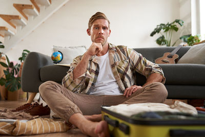 Senior woman using phone while sitting on sofa at home