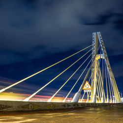 Illuminated bridge against sky at night