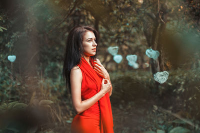 Young woman standing in forest